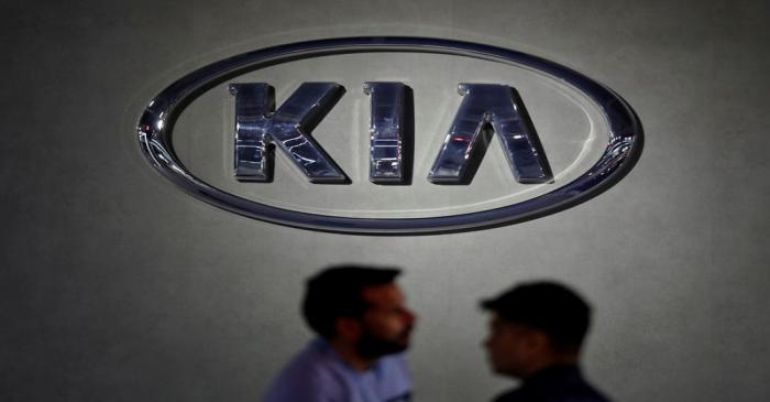 Visitors walk past the logo of Kia Motors at its pavilion at the India Auto Expo 2020 in