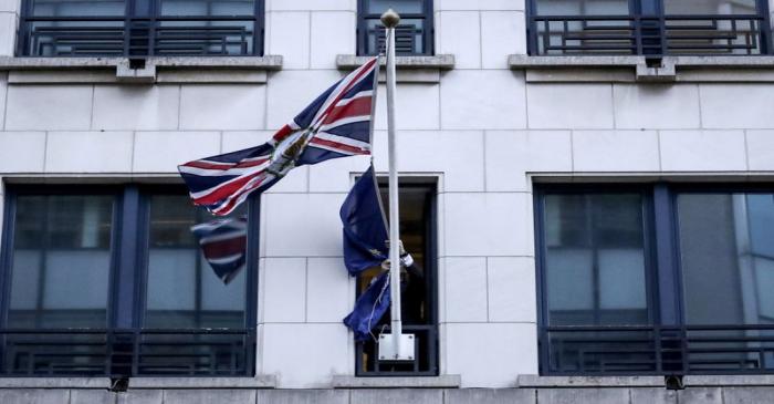 An official removes the EU flag from Britain's Permanent Representation to the EU in Brussels