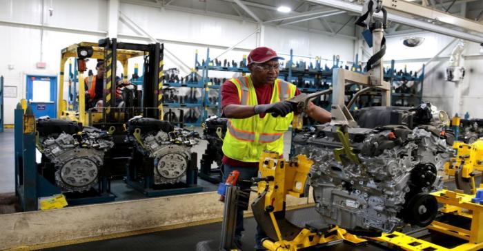 FILE PHOTO: A General Motors assembly worker moves a V6 engine, used in a variety of GM cars,