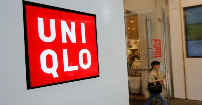 A woman walks past the logo of Uniqlo at Myeongdong shopping district in Seoul