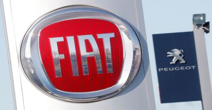 The logos of car manufacturers Fiat and Peugeot are seen in front of dealerships of the