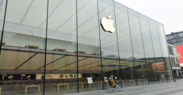 Person riding a shared bicycle is seen outside a closed Apple store near the West Lake in