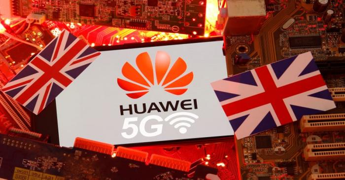 The British flag and a smartphone with a Huawei and 5G network logo are seen on a PC