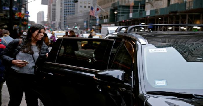 FILE PHOTO: A passenger enters an Uber car in New York City