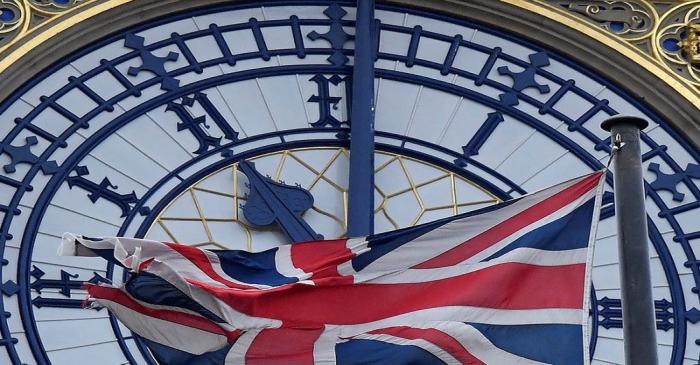 The British union flag is seen fluttering as the clock face of Big Ben shows eleven o'clock,