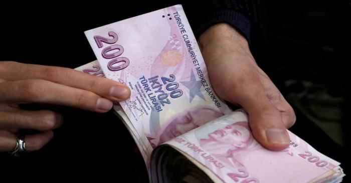 FILE PHOTO: A merchant counts Turkish lira banknotes at the Grand Bazaar in Istanbul