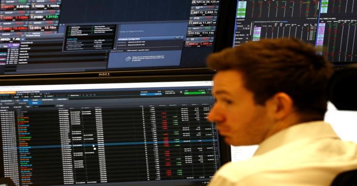 A financial trader works at their desk at CMC Markets in the City of London