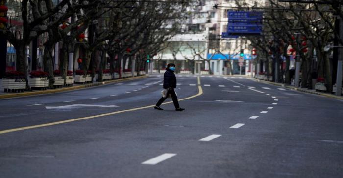 A woman wearing a mask is seen at a main shopping area, in downtown Shanghai