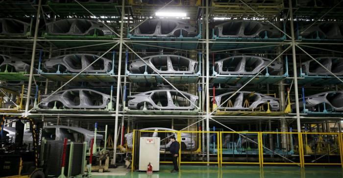 A worker stands in front of parts of Hyundai Motor's sedans at its plant in Asan