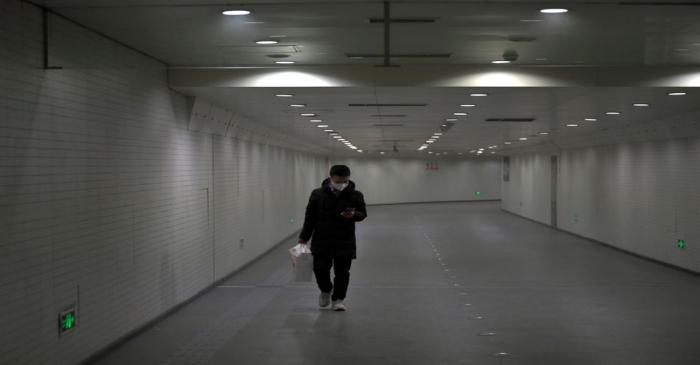 FILE PHOTO: Man wearing a face mask walks in a subway station, following an outbreak of the