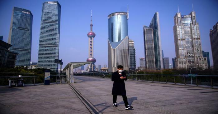 FILE PHOTO: A man wearing a mask is seen at Lujiazui financial district in Pudong, Shanghai