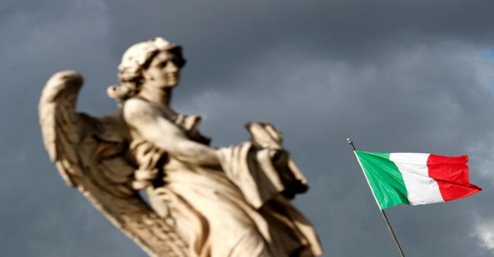 FILE PHOTO: An Italian flag waves behind a statue near Ponte Sant'Angelo in Rome