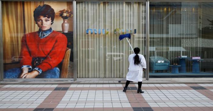 FILE PHOTO: A woman cleans the shop window of a boutique of the Italian high fashion brand Miu