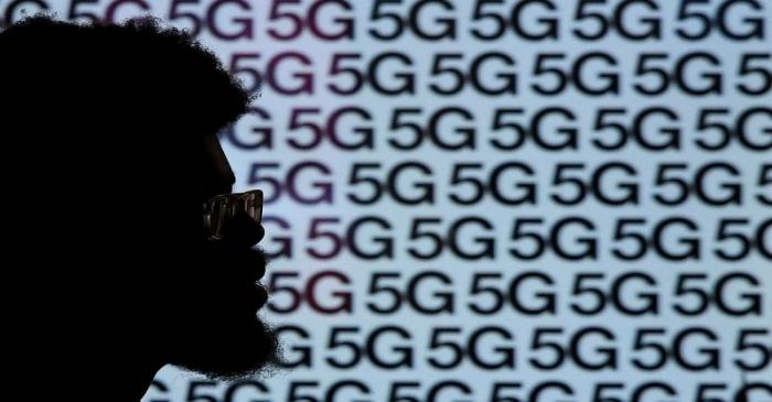 A man walks past an advertisement promoting the 5G data network at a mobile phone store in