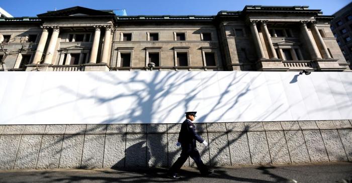 A security guard walks past the front of the Bank of Japan headquarters in Tokyo