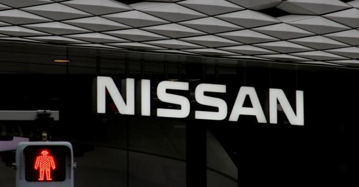 The logo of Nissan Motor Co. is seen at its show room behind a traffic sign in Tokyo