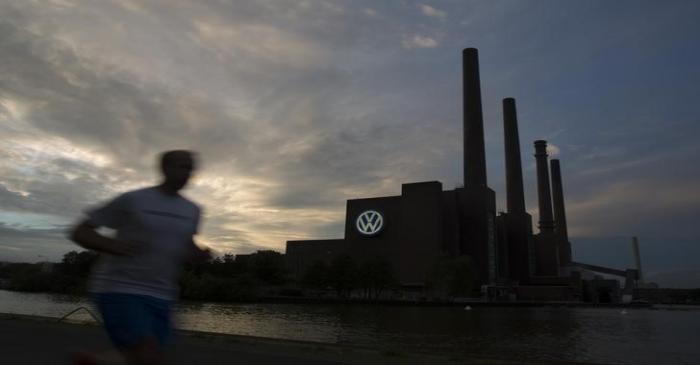 Jogger runs along bank of Midland Canal in front of Volkswagen power plant in Wolfsburg