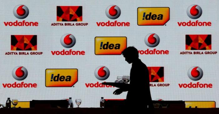 FILE PHOTO: A hotel employee clears a table after Vodafone Group and Idea Cellular news