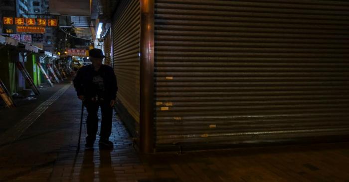 A man walks past a closed shop following the outbreak of the new coronavirus, in Hong Kong