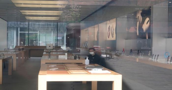 FILE PHOTO: Security personnel wearing a face mask is seen in a closed Apple store at Sanlitun