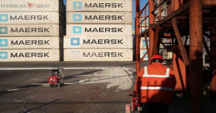 FILE PHOTO: Worker is seen next to Maersk shipping containers at a logistics center