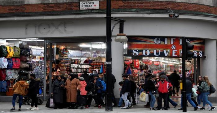 Shoppers walk past a former branch of the British clothing retailer Next, now converted into an