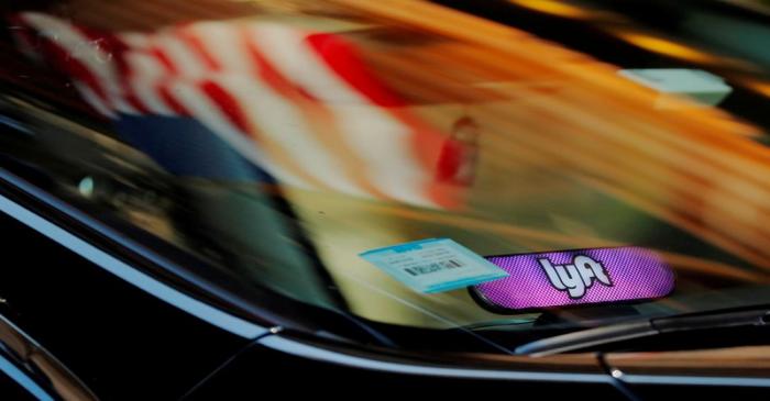 FILE PHOTO: A car with a Lyft logo in its window drives down a street as the company prepares