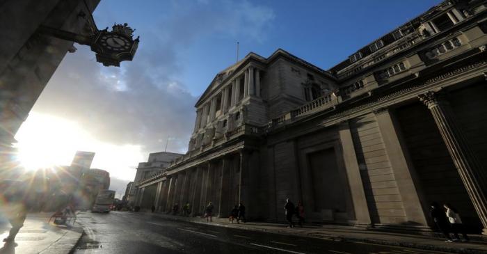 Pedestrians walk past the Bank of England in the financial district in London