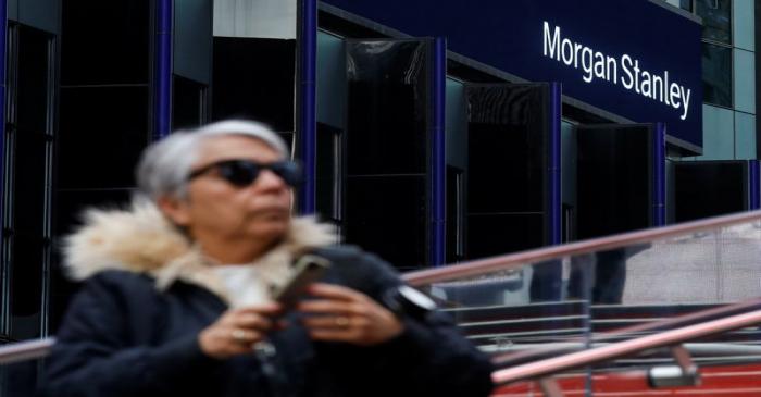 A woman takes photos by the Morgan Stanley building in Times Square in New York