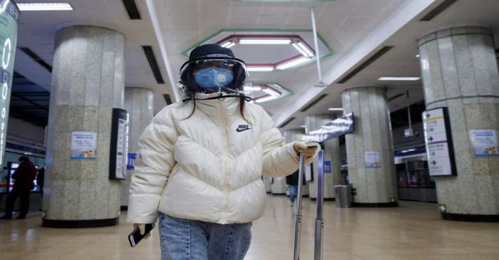A woman wears a face mask at a metro station in Beijing as the country is hit by an outbreak of