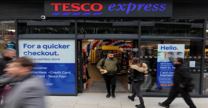 Pedestrians walk past a Tesco's Express supermarket, its first cashless store in London,