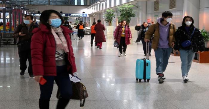 FILE PHOTO: Passengers wearing masks are seen at the terminal hall of the Beijing Capital