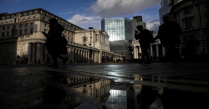Pedestrians walk past the Bank of England in the financial district in London