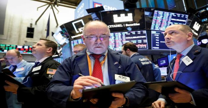 FILE PHOTO: Traders work on the floor at the NYSE in New York