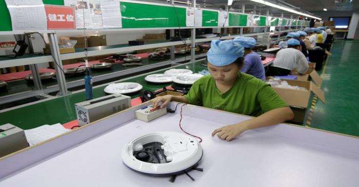 FILE PHOTO: An employee works on the production line of a robot vacuum cleaner at a factory of