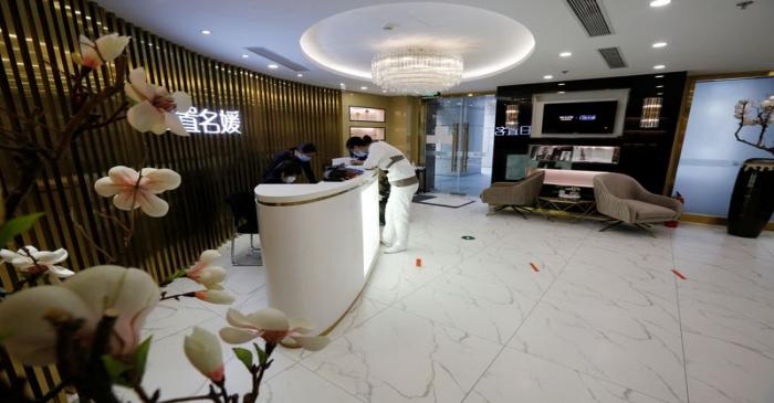 Staff members wearing face masks are seen at the reception area of the Pearl Deluxe beauty spa