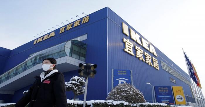 Women wearing a face mask walks past a closed IKEA store in Beijing