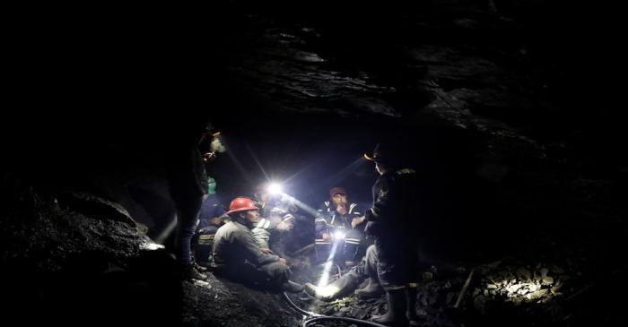 Artisanal gold miners talk as they sit inside a gold mine in La Rinconada, in the Andes