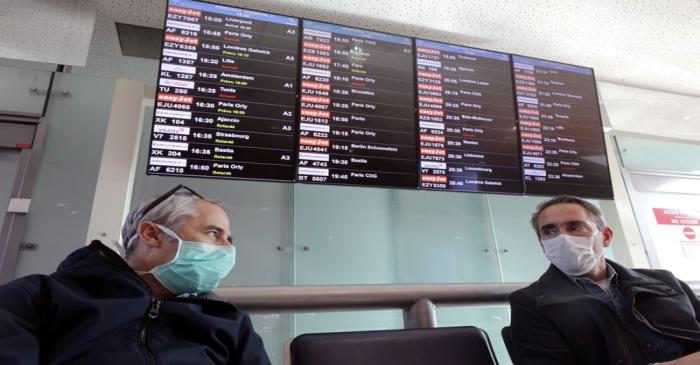 FILE PHOTO: Travellers wearing protective face masks wait for their flights at Nice