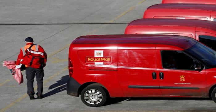 FILE PHOTO: A postal worker carries mail bags from a van at a Royal Mail sorting office in