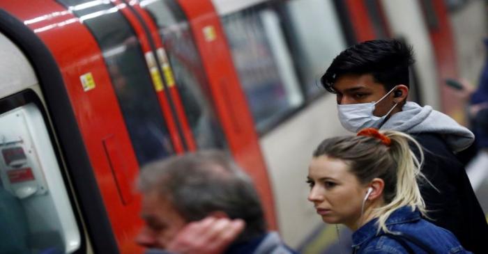 Commuters wait to board a Northern Line tube at Clapham North underground station during rush