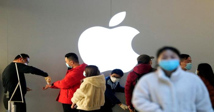 FILE PHOTO: People wearing protective masks wait for checking their temperature in an Apple