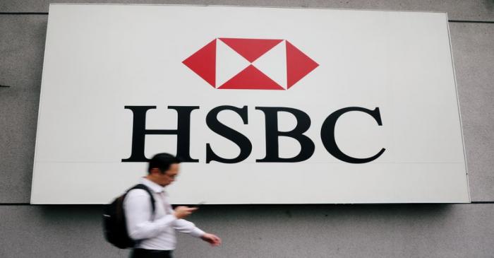 FILE PHOTO: A man walks past a logo of HSBC at its headquarters in Kuala Lumpur