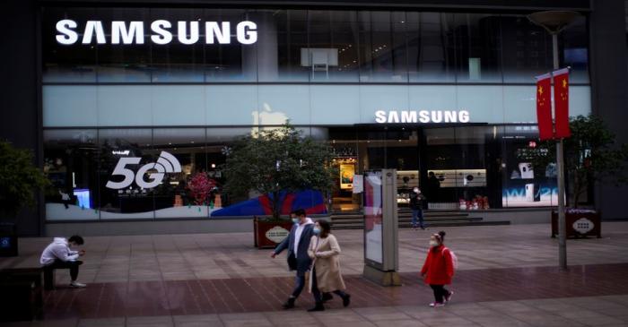 People wears masks in front a Samsung Store at a main shopping area, in downtown Shanghai