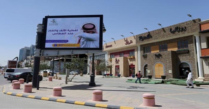 People walk near a banner with an instruction on personnel hygiene, following the outbreak of