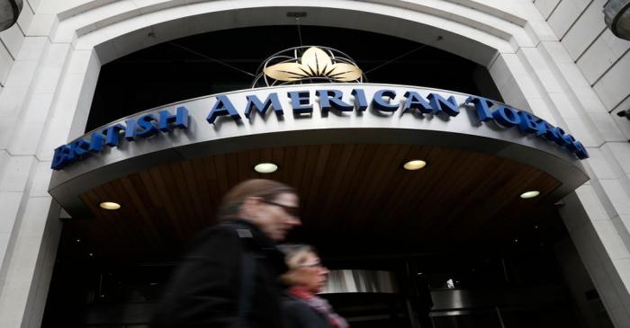 FILE PHOTO:  People walk past the British American Tobacco offices in London