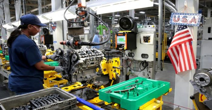 FILE PHOTO: A General Motors assembly worker works on assembling a V6 engine, used in a variety