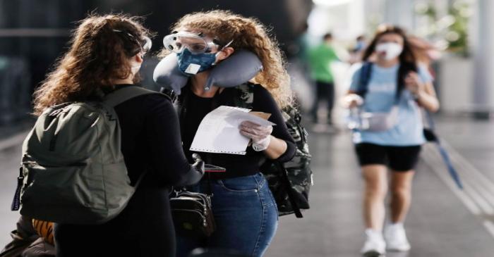 People wear protective face masks at international arrivals area at Guarulhos International