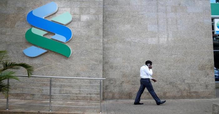A man walks past a logo of the Standard Chartered Kenya bank in their main office in Nairobi,
