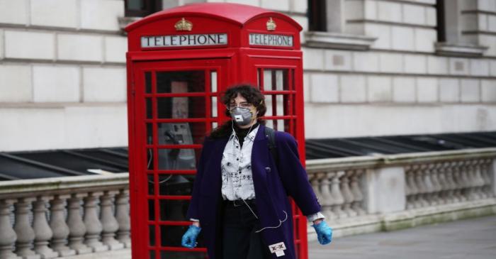 A woman wearing a protective face mask and gloves